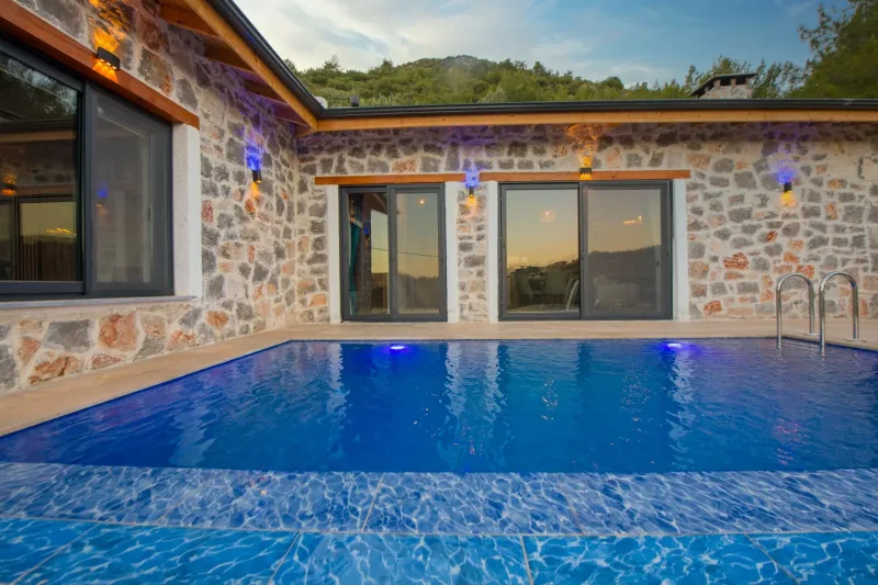 İnlice'de Muhteşem Manzaralı Kiralık Havuzlu Taş Villa – Akşam Saatinde Mavi Işıklı Özel Havuz ve Sedir Kirişli Ön Cephe