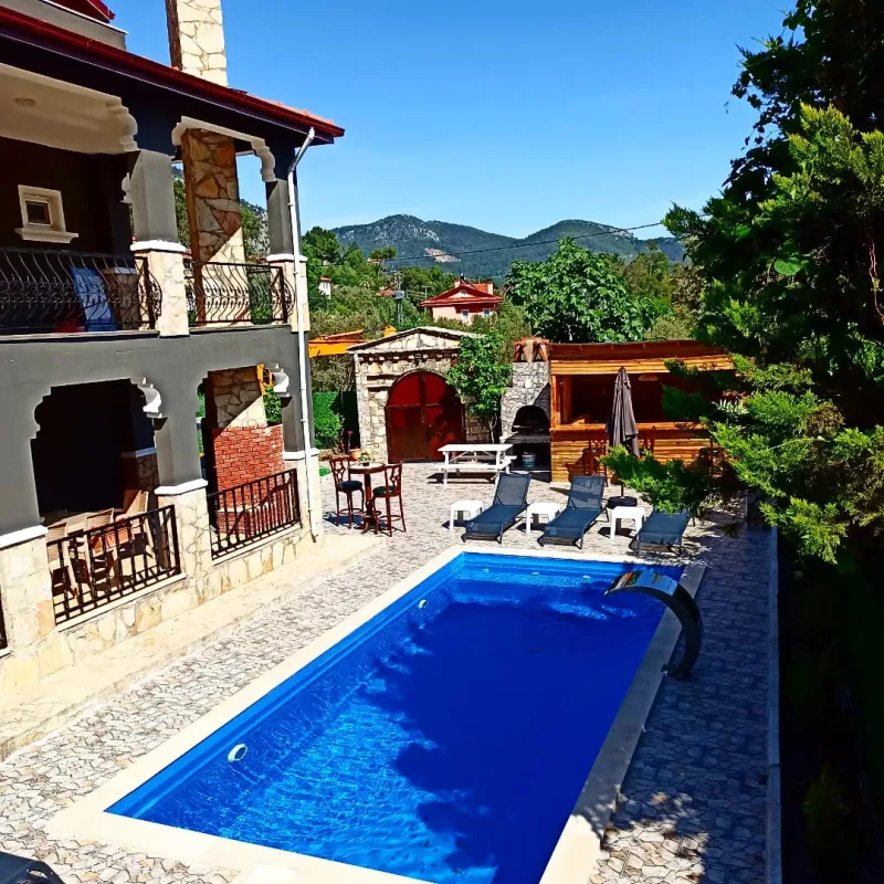 Göcek tesisinde özel yüzme havuzu, şezlonglar ve ahşap bar