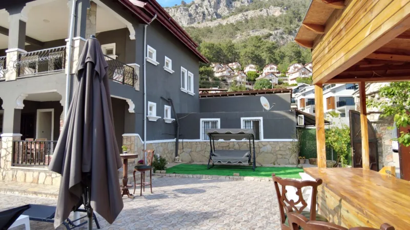 Göcek tesis avlusunda salıncak, şemsiye ve ahşap bar tezgâhı