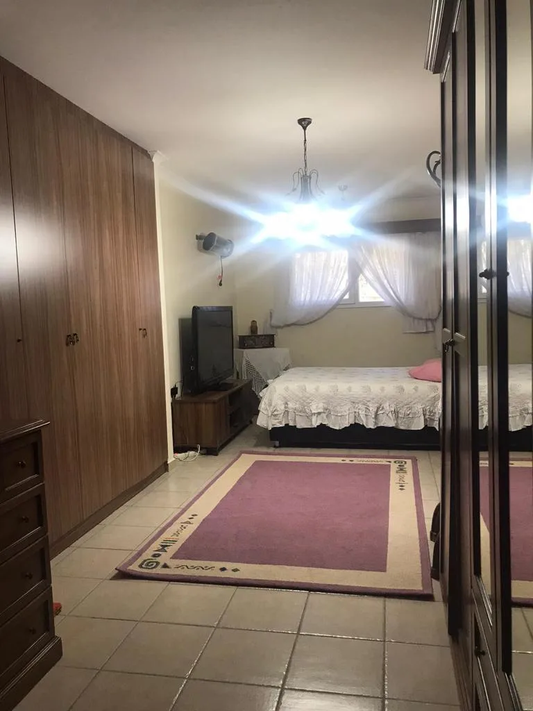 Ahşap gardıroplu klimalı yatak odası ve pembe halı