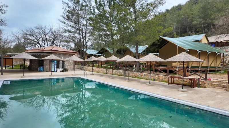 Gökçeovacık glamping havuzu, hasır şemsiyeler ve safari çadır sırası