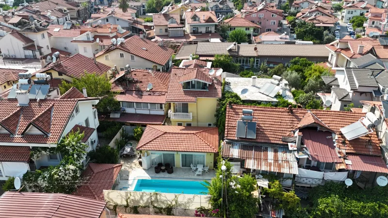 Göcek merkezde sarı cepheli havuzlu villa drone çekimi