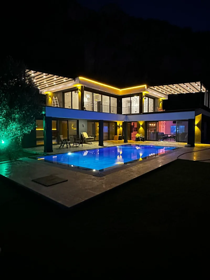 Gece aydınlatmalı infinity havuzlu modern Göcek villası dış görünüm