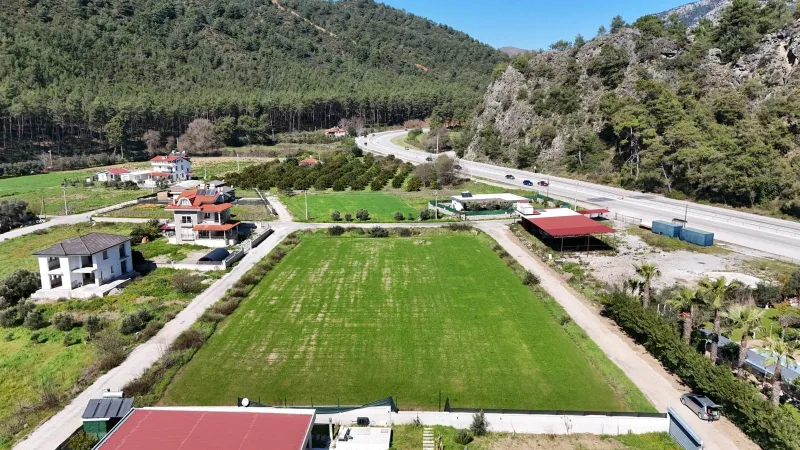 İnlice satılık arsa – çam ormanlı dağ önünde düz yeşil alan ve çevredeki villalar