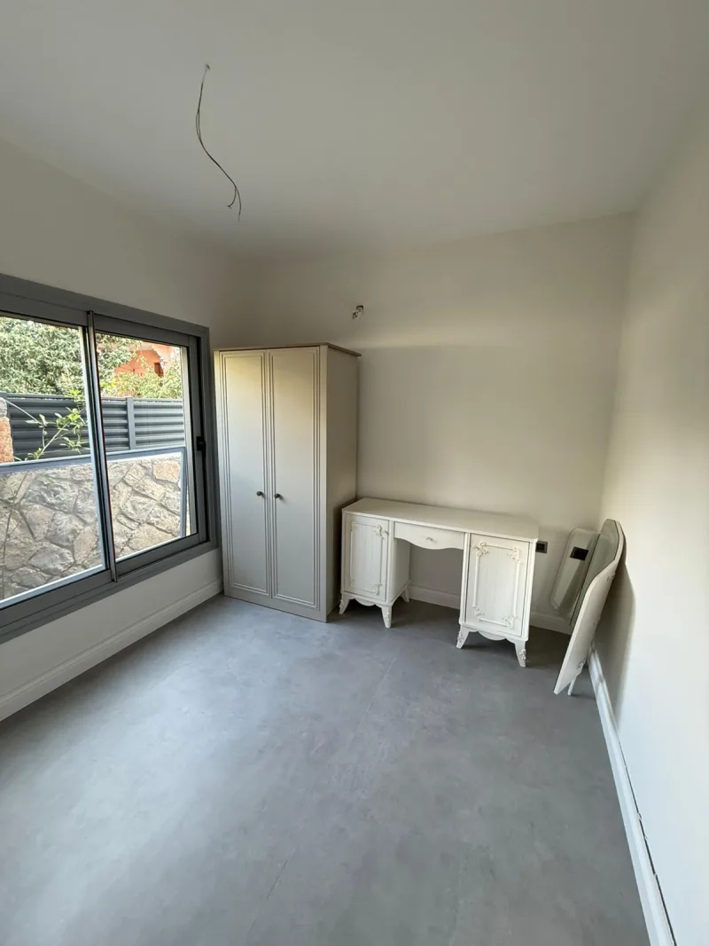 Göcek kiralık villa yatak odası – gardırop, makyaj masası ve bahçe manzaralı pencere