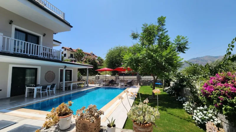 Göcek doğa içinde havuzlu kiralık villa, veranda yemek alanı ve şemsiyeli havuz terası