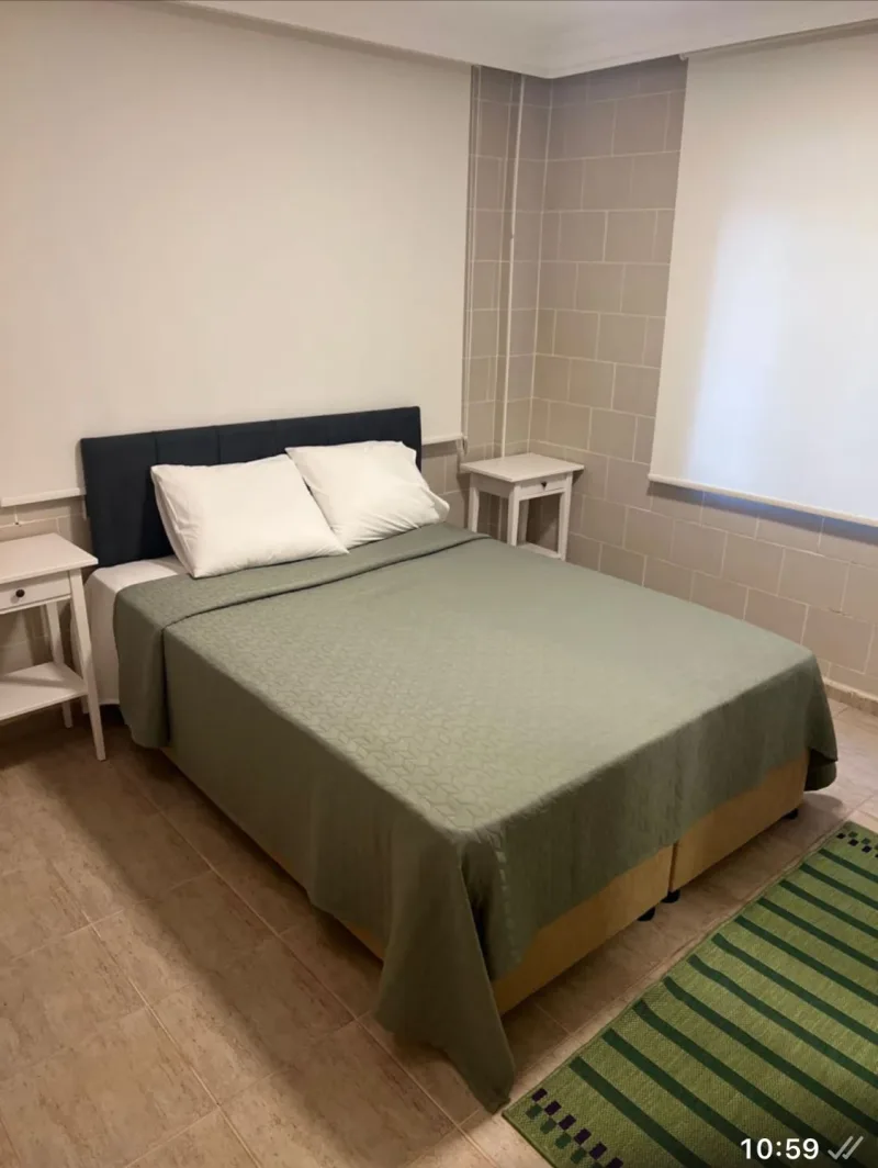 Göcek kiralık 2+1 daire çift kişilik yatak odası, yeşil nevresim ve beyaz komodinler