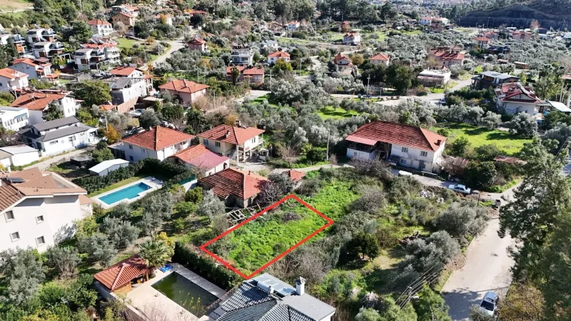 Dereboğazı 400 m² satılık arsa; tepeden kırmızı çizili yeşil arsa, zeytinlikler ve yanındaki yüzme havuzları